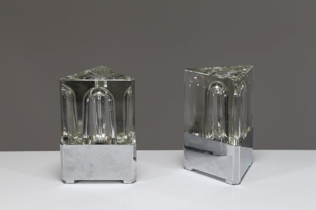 FIDENZA VETRARIA Coppia di lampade da tavolo in vetro: FIDENZA VETRARIA Coppia di lampade da tavolo in vetro massello e metallo cromato, prod. Fidenza Vetraria, anni 70. -. Cm 13,00 x 19,00 x 13,00.