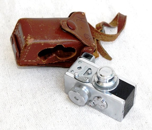 1951 Spy Camera with Lens Cap and Leather Case: 1951 Spy Camera comprising circa 1950 Riken Steky 16mm, f3.5 2.5cm standard lens, leather case, 2 x film cassettes and instruction booklet. Approximately 2 1/2" high by 1 1/2" wide.