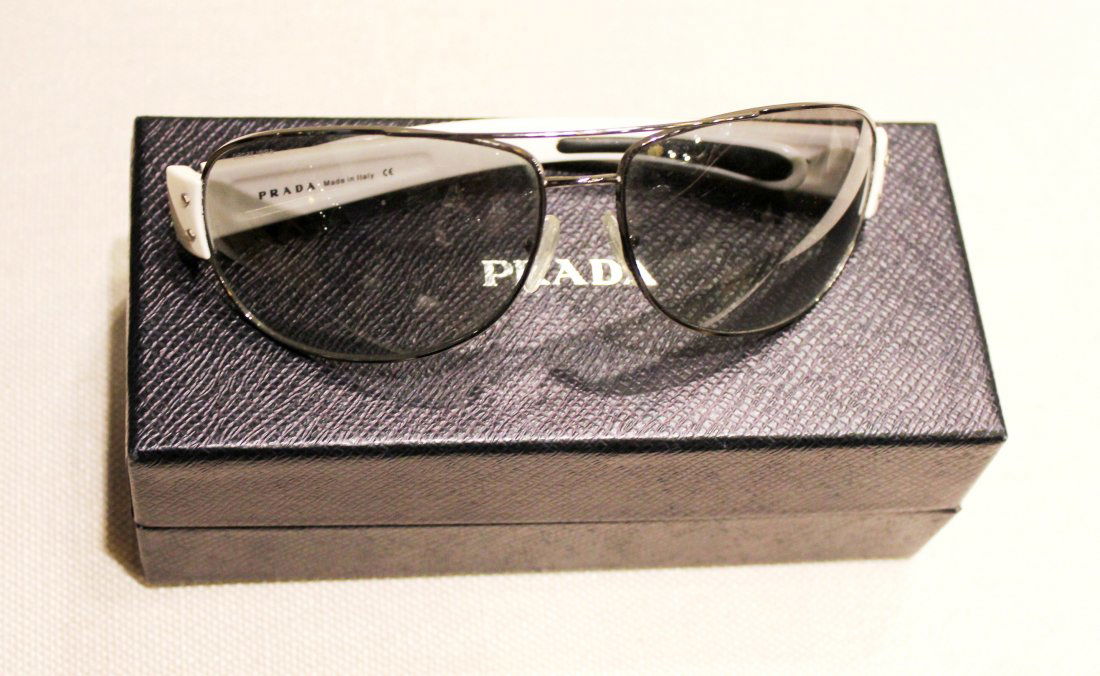 Men's Prada Sunglasses: Prada Sunglasses. Model #: SPS 52G. Prada Sports Series. Aviator Style. Gunmetal Frames, White Temple. Gray Gradient Lenses. Red Prada Logo on Left Temple Side. 100% UV Protection. Made in Italy.