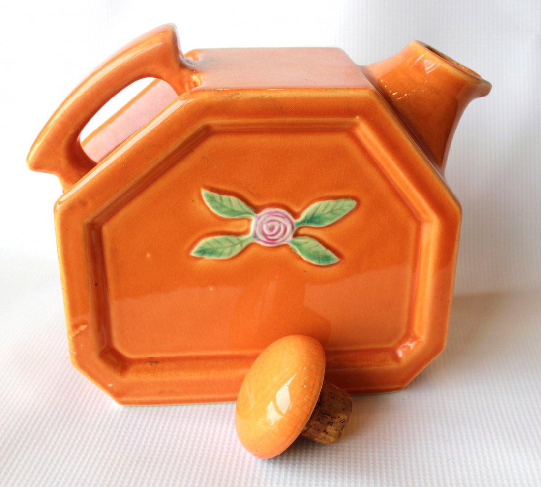 Vintage Orange Water Jug: Vintage Crackle Ceramic Water Jug. Geometric with Rose and Leaf Pattern on either side. Has Cork Stopper. Orange in color. Measures approximately 7 1/2" High x 9" Wide x 3 1/2" Deep.