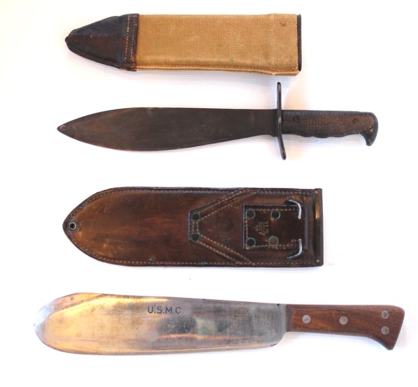 Lot of Two Machetes: 1918 style Scabbard and WWII USMC Bolo Knife In excellent unused condition, the bright blade has a few spots of discoloration, maker marked "The Clyde Cutlery Co Clyde Ohio USA". Wood handle has a few