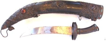 19th Century Mongolian Scabbard Beaded Sword: Antique Mongolian scabbard sword having raised repousse designs throughout depicting scrolled flowers with dragons. 4 high relief pale green jade plaques set to sides depicting dragons. Jeweled throug