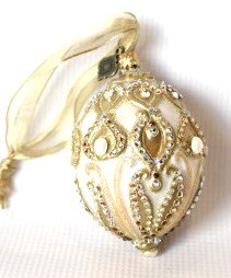 Jay Strongwater Crystal Ornament- Oval Cream Shape: Jay Strongwater Oval Cream Ornament. Pearl Details. Colors include: pearl, white, gold and amber. Measuring approximately 4 x 2.5.