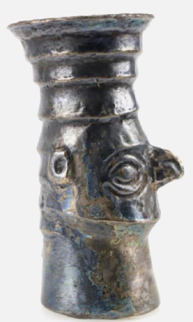 PRE-COLUMBIAN CHIMU SILVER FACE BEAKER: PRE-COLUMBIAN CHIMU SILVER FACE BEAKER, CA 1100-1400 AD, 5 1/4" H, HAMMER-MOLDED SILVER CEREMONIAL DRINKING VESSEL WITH MULTI-STEPPED HAIRDO AND FLARING RIM, WHICH HAS A FINE CROSSHATCHED DECORATION. 