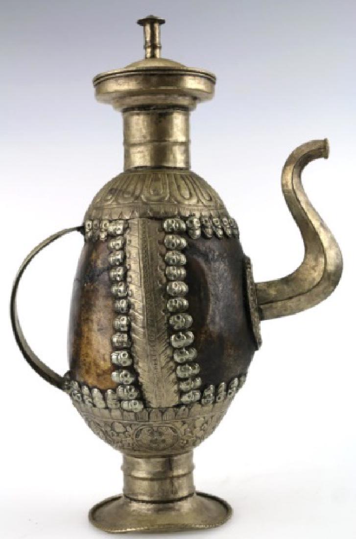 TIBETAN ANTIQUE SKULL RITUAL EWER: ANTIQUE TIBETAN HUMAN SKULL EWER, 19TH-EARLY 20TH CENTURY, 13 1/4" H, CEREMONIAL VESSEL WITH THE BODY COMPOSED OF TWO HUMAN CRANIA, BORDERED AND FITTED WITH BASE-SILVER HARDWARE, EDGED WITH INDIVIDUAL