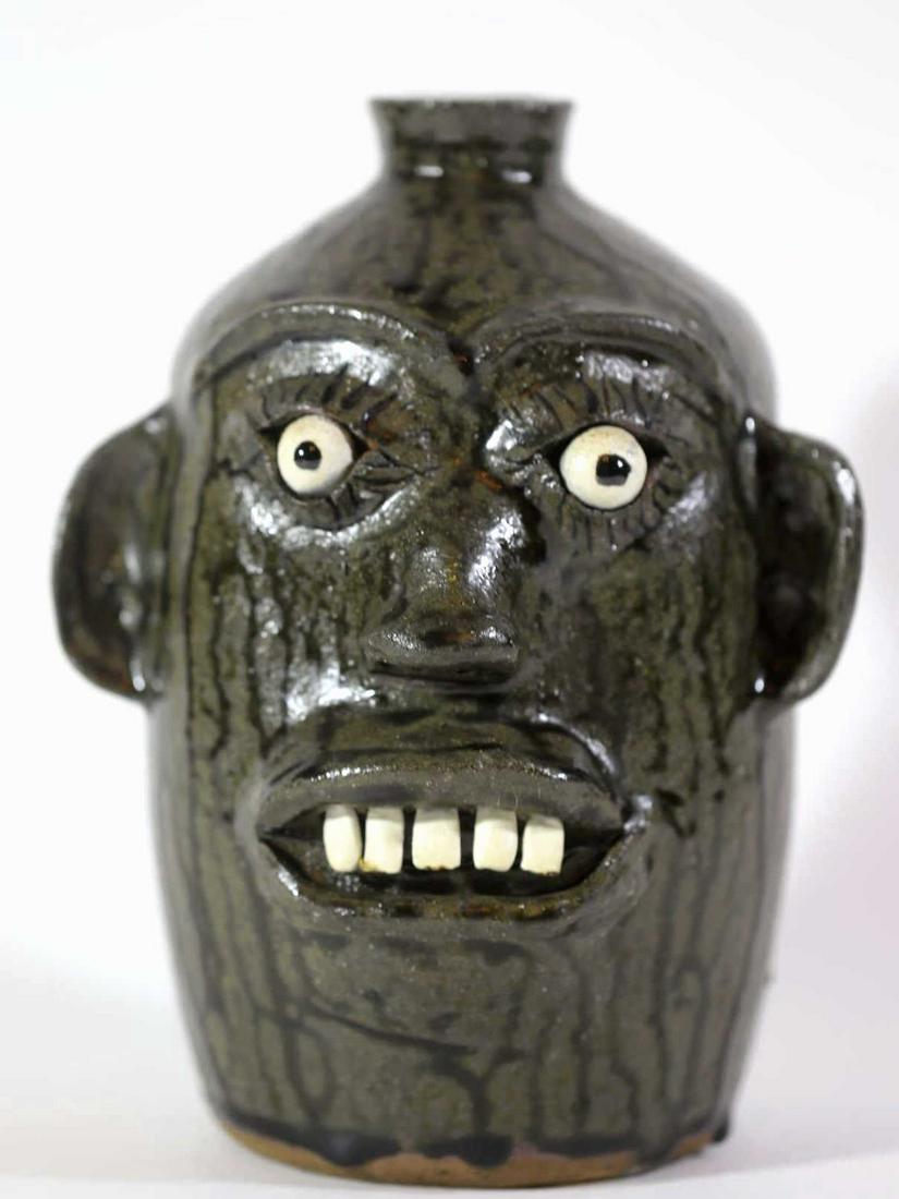 A G MEADERS (GA, 1923-1993) FOLK ART FACE JUG: A LVA GUSTA MEADERS (1923-1993), SON OF CLEATER JAMES MEADERS, WHITE COUNTY, GEORGIA, FOLK ART POTTERY FACE JUG, HIGH GLOSS ALKALINE GLAZE FACE JUG, MARKED AG MEADERS 1987