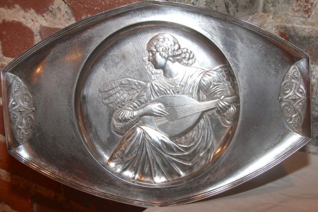 19th Cent. Silver Angel Charger by Luisana Designs: 19th century silver plate probably WMF, but unsigned. The dimensions are 11.5” x 17". Suggested retail $250.00. Donated by Luisana Designs and Antiques at Market Square, Floor: Mezzanine/Antique & D