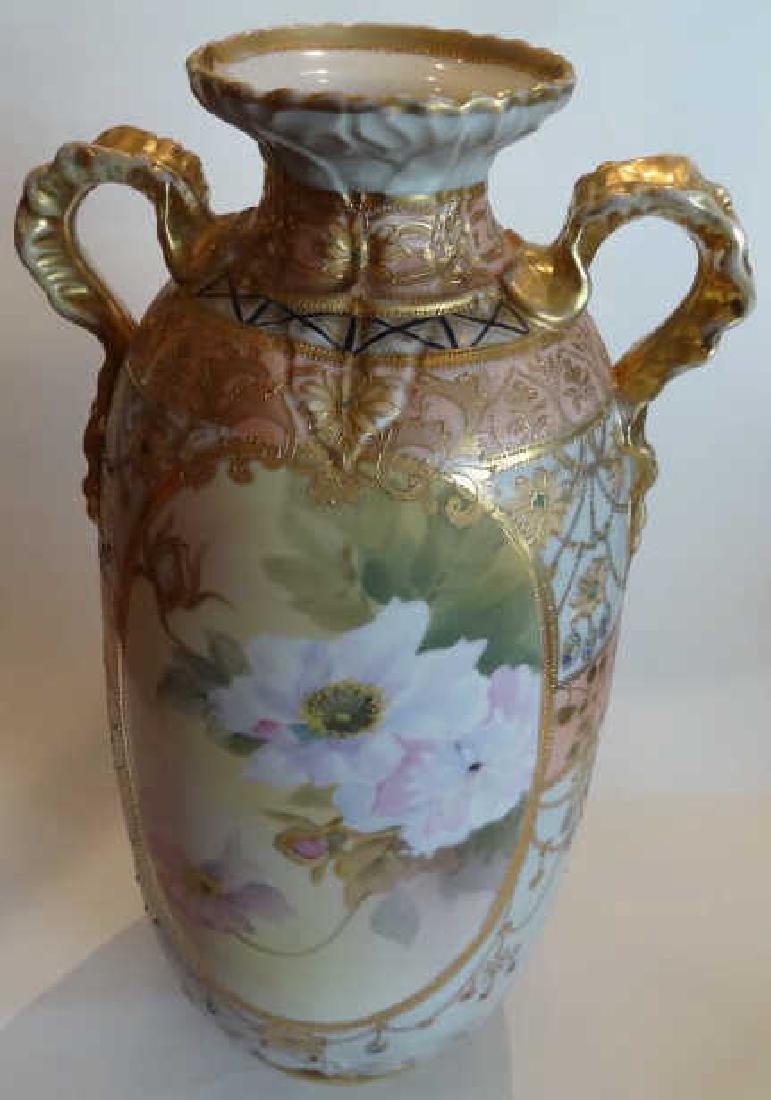 NIPPON SATIN FINISH RIBBON HANDLED VASE: Nippon Satin Finish Ribbon Handled Vase: Ribbon handles on satin finish vase with bottom displaying raised calla lillies. Vase is decorated with dogwood flowers. Vase is 12 1/2" high. Good condition.