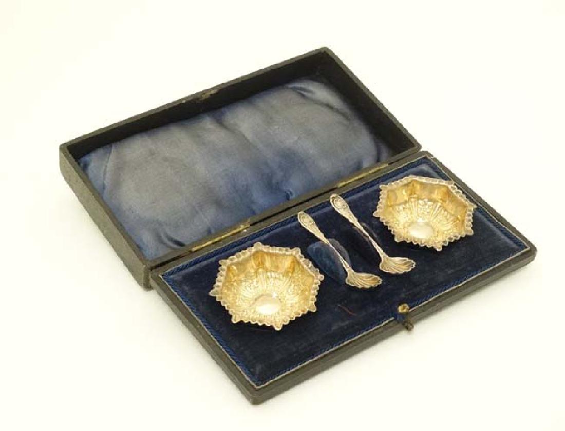 Cased salts of octagonal form one hallmarked Sheffield: Cased salts of octagonal form one hallmarked Sheffield 1899 maker GHH the other Birmingham 1899 maker William Devenport. Together with 2 associated silver salt spoons hallmarked Birmingham 1897 maker 