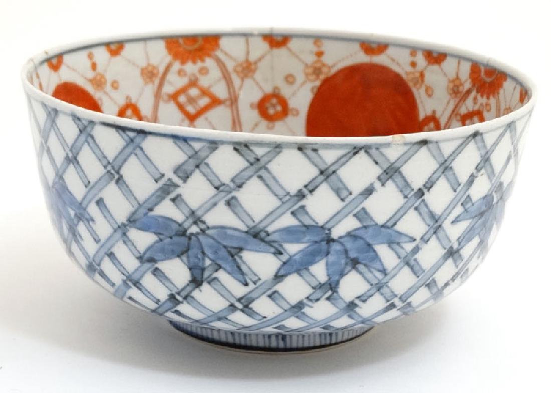 A Chinese blue and white bowl decorated with stylised: A Chinese blue and white bowl decorated with stylised bamboo and foliage to outer , 3 clawed dragon to interior well and red and white detail to inner rim, bears blue Chinese 4 character mark to base.