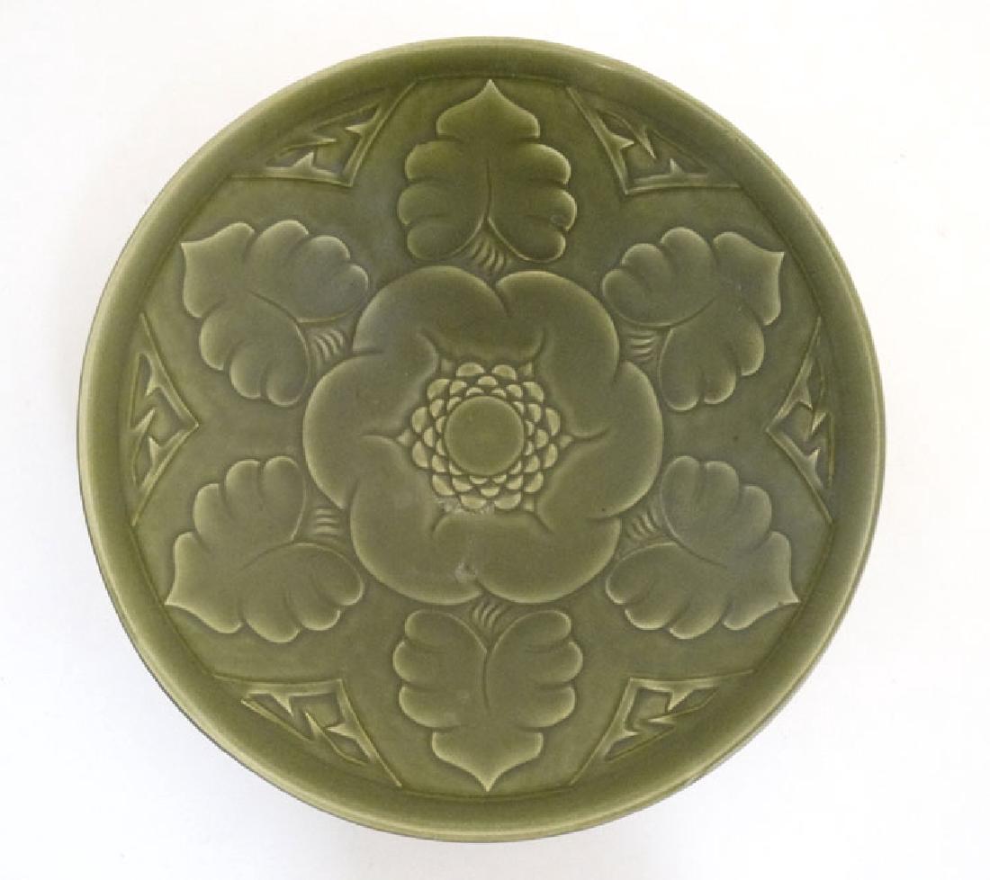 Scandinavian Pottery: An early / mid 20thC Bo Fajans,: Scandinavian Pottery: An early / mid 20thC Bo Fajans, Gavle, Sweden pottery dish , decorated with stylised flora on a green ground, bears impressed factory stamp to base. 10'' diameter.