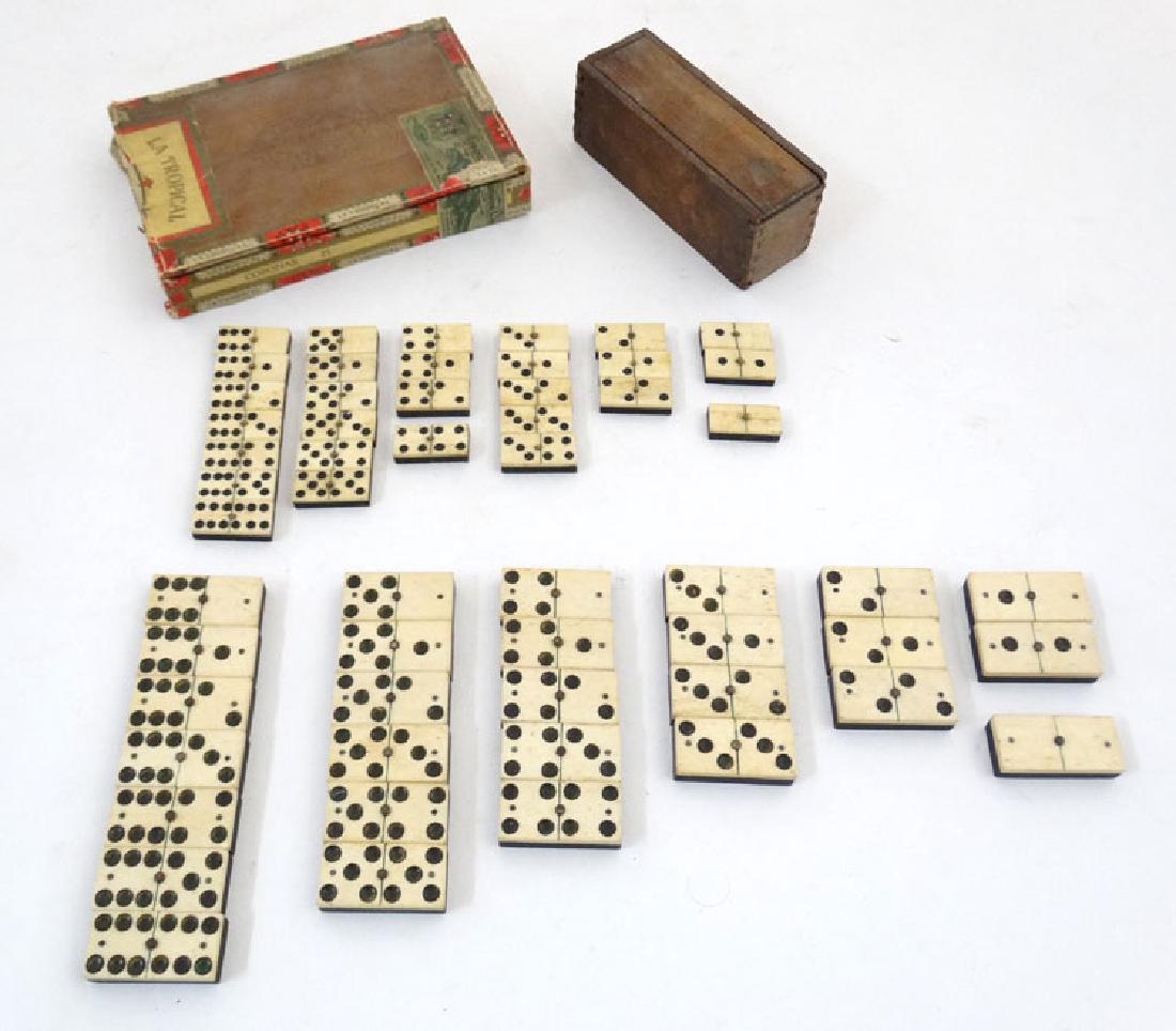 Toy: Two sets of hand carved bone and Ebony dominoes,: Toy: Two sets of hand carved bone and Ebony dominoes, the larger set 2'' long , the smaller 1 1/2'' long, smaller set in box.