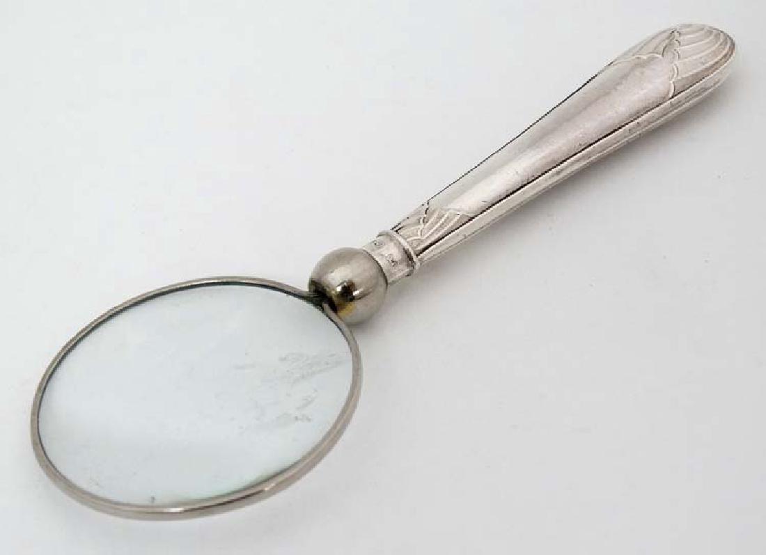 A magnifying glass with silver handle. The whole 5'': A magnifying glass with silver handle. The whole 5'' long