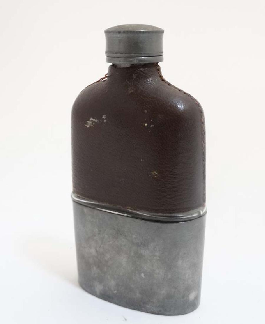 A hip flask with half leather covering and beaker to: A hip flask with half leather covering and beaker to base 5'' high