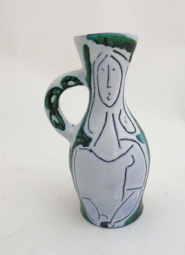 A 1950s French pitcher in the manner of Jacques: A 1950s French pitcher in the manner of Jacques Innocenti, decorated with stylised abstract female figure (influenced by Pablo Picasso), in typical matt black on a white crackle glazed ground with gre