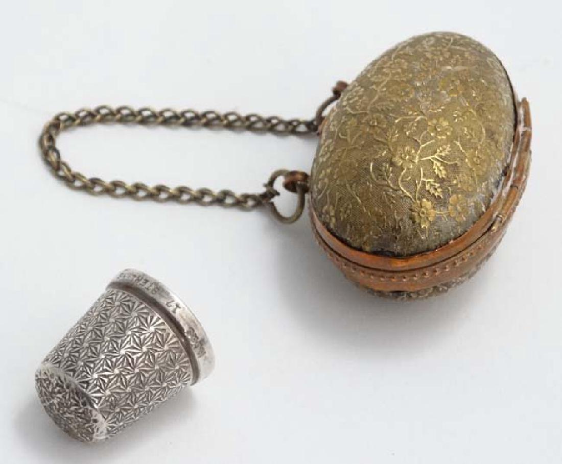 Needlework / Sewing : A Victorian gilt metal thimble: Needlework / Sewing : A Victorian gilt metal thimble case of egg form with floral decoration and hanging chain, opening to reveal a Sterling Silver Thimble ' The Spa' maker HG & S. The case 1 3/4'' lo