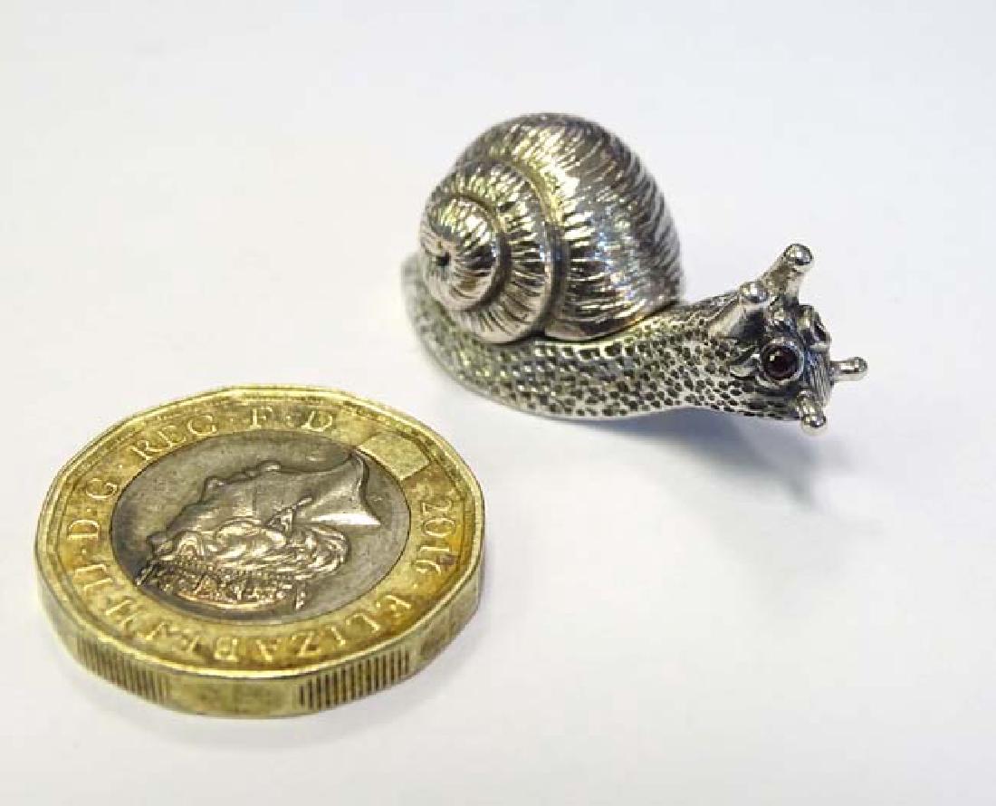 A silver miniature model of a snail, the shell hinging: A silver miniature model of a snail, the shell hinging open to form a pill box. 21stC 1 1/2'' long