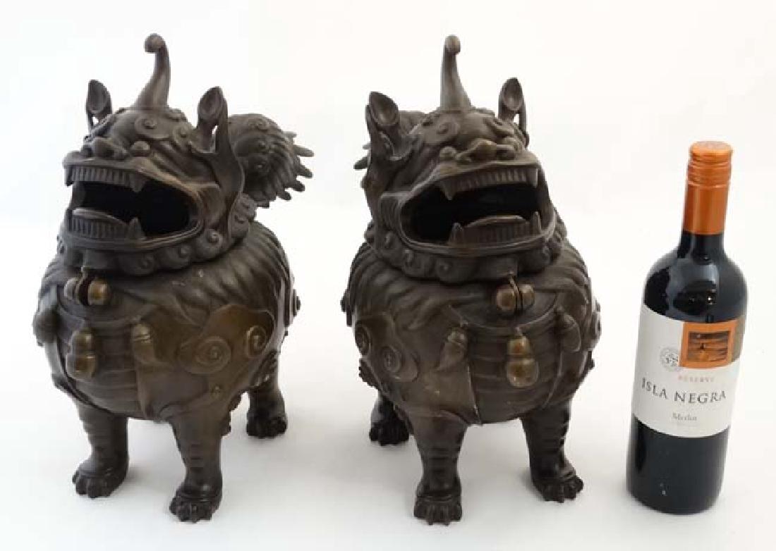 A pair of Chinese sensors formed as Qilin (Ch'i-lin :: A pair of Chinese sensors formed as Qilin (Ch'i-lin : Chinese unicorn), each bearing 4 character marked under, with hinged heads. 13 1/2'' high x 14'' long