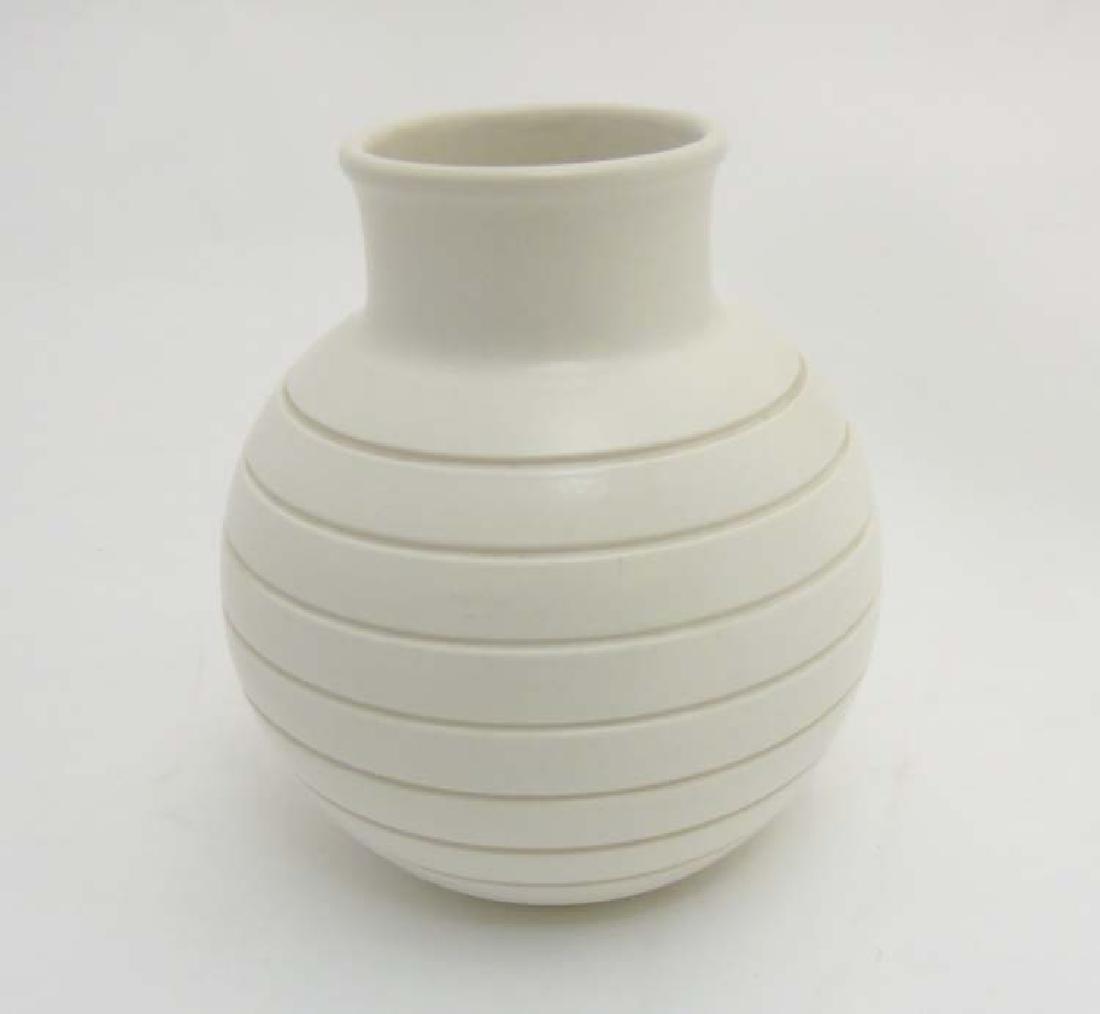 An Art Deco c1930/40 Keith Murray Wedgwood Moonstone: An Art Deco c1930/40 Keith Murray Wedgwood Moonstone earthenware vase, covered in a white glaze with carved horizontal band detail to body, makers mark to base, 6 1/4'' high