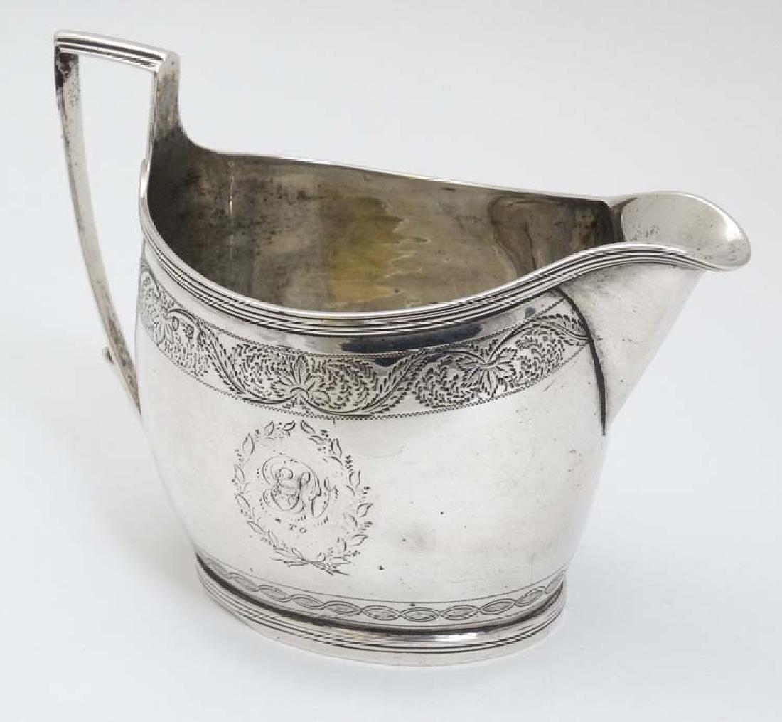 A Geo III silver cream jug  with engraved decoration (1 of 6)
