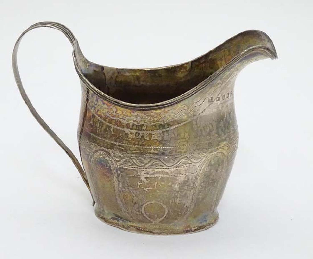 A Geo IIl silver cream jug with engraved decoration and (1 of 7)