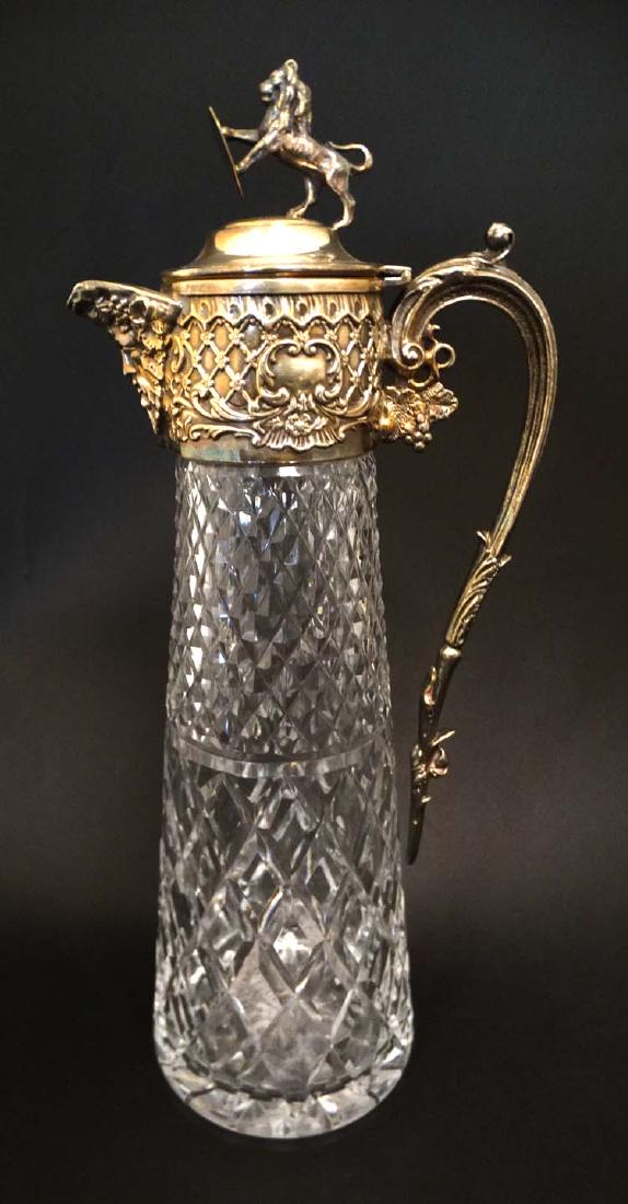 Glass : a claret jug with silver plate top and hinged: Glass : a claret jug with silver plate top and hinged lid ( with rampant lion holding a shield to top, Rococo , Bacchus and grapevine decoration , the glass body with hobnail cut decoration ,measuring
