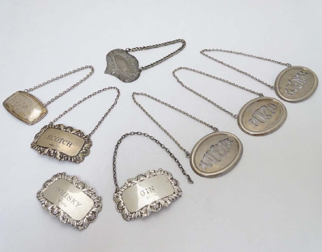 Assorted decanter / wine labels / bottle tickets to: Assorted decanter / wine labels / bottle tickets to include 2 silver examples for ' Gin' and 'Whiskey' hallmarked London 1967, another silver example hallmarked 'Scotch' together with a silver plate '