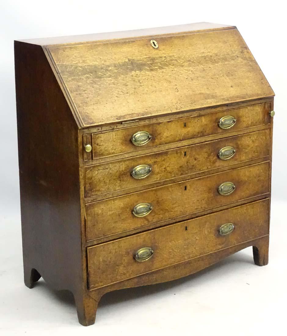 A Georgian oak bureau with four long drawers and a: A Georgian oak bureau with four long drawers and a drop-down section opening to reveal fitted drawers and compartments, standing on bracket feet with a shaped apron. 39'' long x 19'' wide x 41 Â½'' 