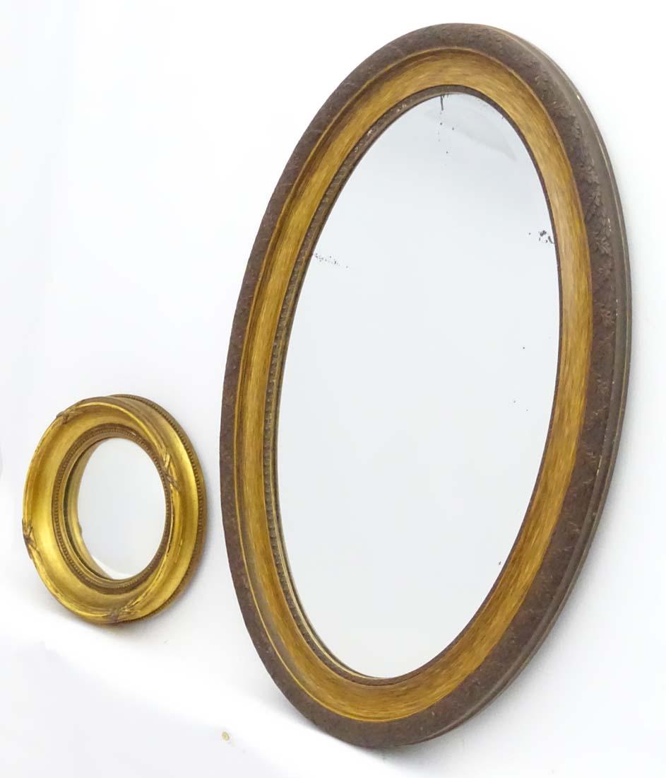 A Victorian gilt circular convex mirror together with: A Victorian gilt circular convex mirror together with an early 20thC gilt oval mirror. 12'' in circumference and the second measuring 32 Â¾'' long x 22'' high (2)