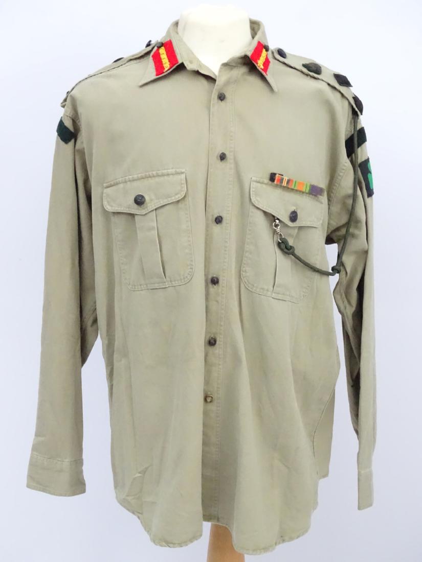 Militaria: A mid-20thC desert battledress shirt, having: Militaria: A mid-20thC desert battledress shirt, having applied Brigadier's gorget patches & epaulette pips, Royal Ulster Rifles regimental buttons and cloth badges, aiguilette and medal ribbons (GSM,