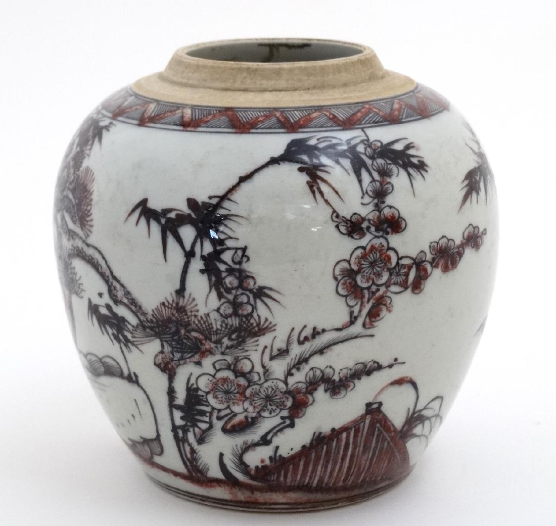 A Chinese red, black and white vase decorated with: A Chinese red, black and white vase decorated with cherry blossom and bamboo on a rocky outcrop, bears blue Chinese 6 character mark to base. 7'' high.