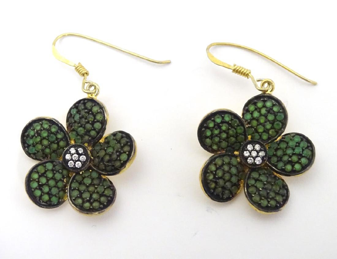 A pair of silver gilt drop earrings of floral form set: A pair of silver gilt drop earrings of floral form set with green and white paste stones. Approx 1'' diameter.