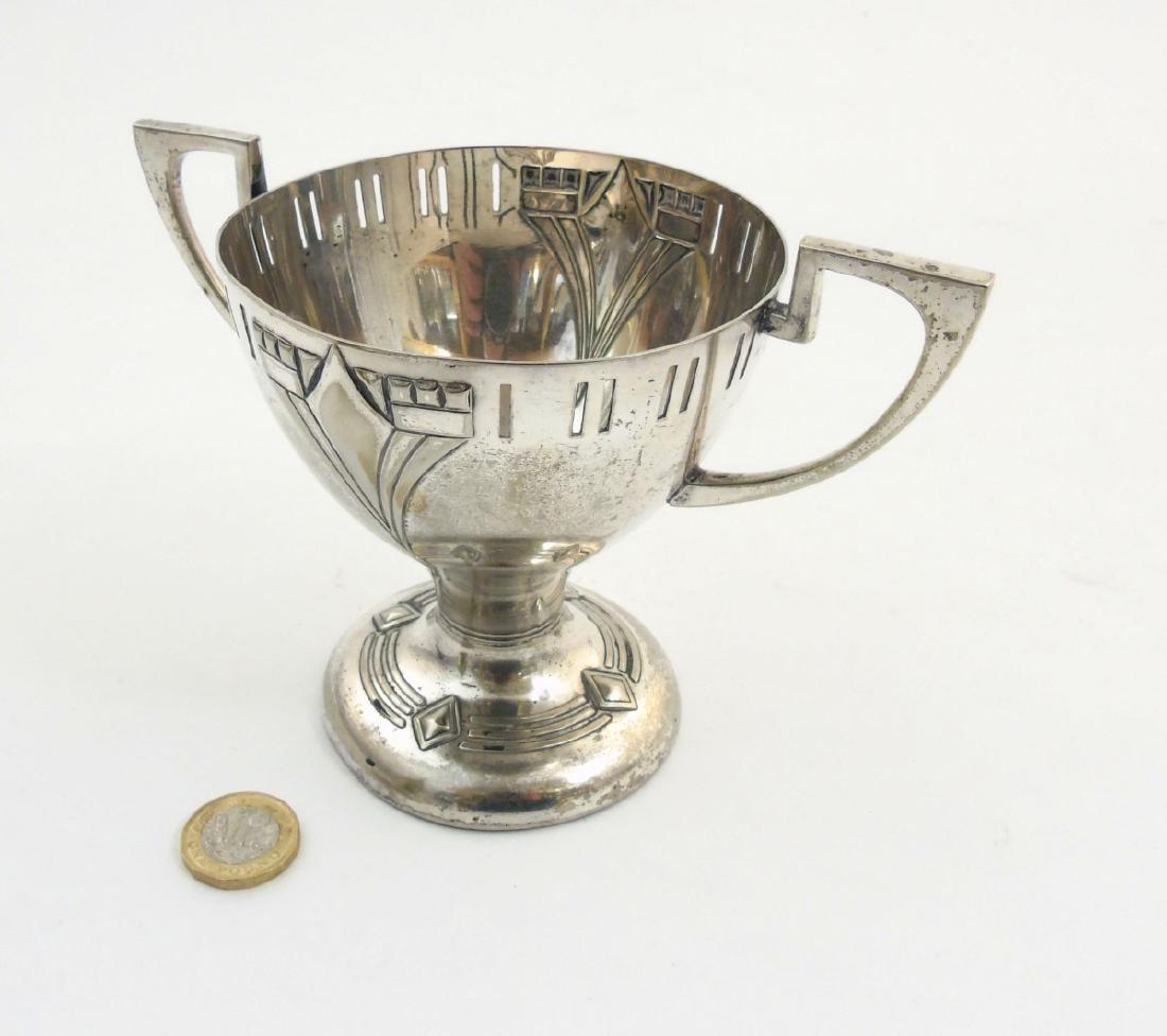 WMF A twin handled silver plate pedestal trophy cup: WMF A twin handled silver plate pedestal trophy cup with embossed decoration. Marked WMF EP NS C under 4 3/8'' high