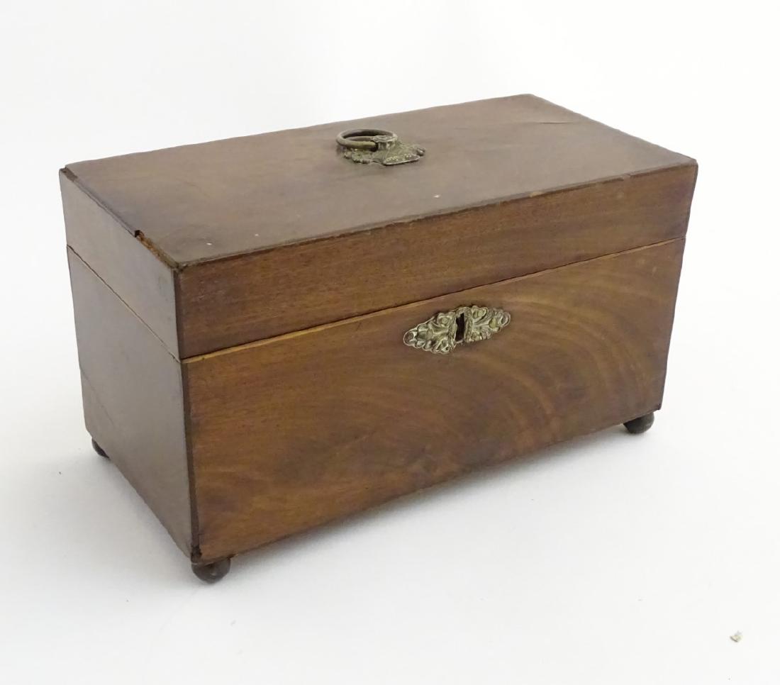 A late 18thC mahogany tea caddy with brass escutcheon,: A late 18thC mahogany tea caddy with brass escutcheon, handle and standing on four feet. 10 5/8'' x 5 1/4'' x 6'' high