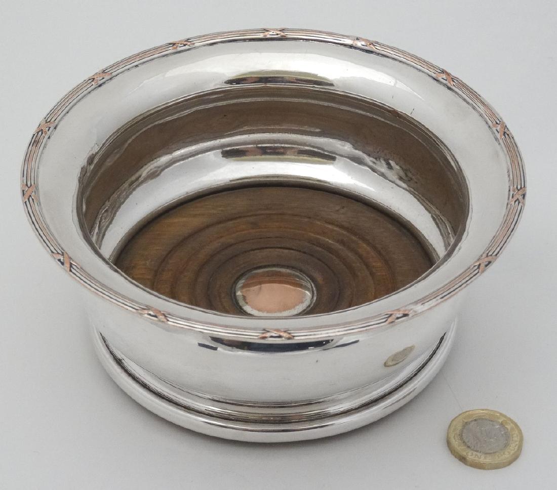 A late 19thC / early 20thC silver plate coaster with: A late 19thC / early 20thC silver plate coaster with turned wooden base 6'' diameter