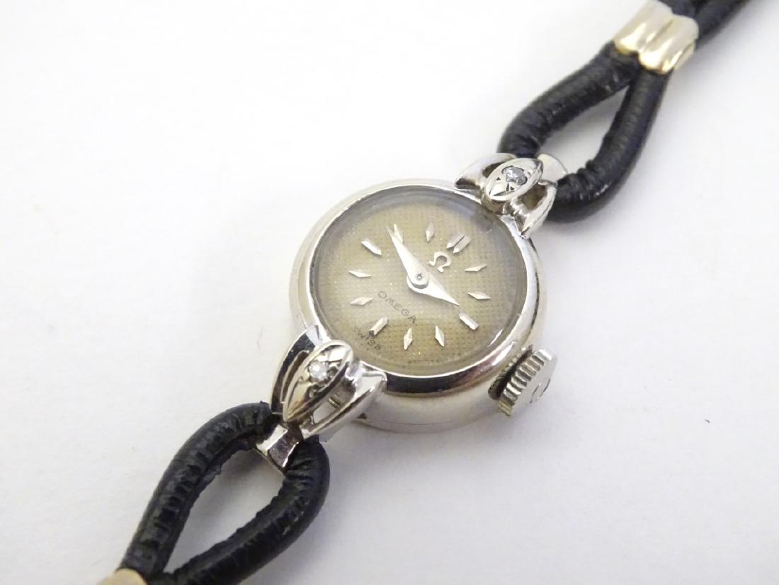 Omega : a ladies 14 k white gold cased wristwatch with: Omega : a ladies 14 k white gold cased wristwatch with 2 inlaid diamonds , signed dial 17 jewel Omega movement no. 14892356 , 0.65'' wide