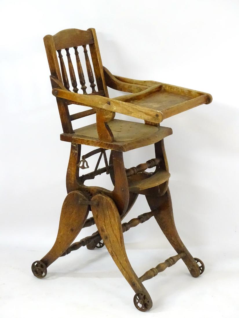 A late 19thC / early 20thC metamorphic childs chair: A late 19thC / early 20thC metamorphic childs chair with spindled backrest and adjustable eating tray, standing on shaped legs with turned supports and moving on metal castors. 39'' high x 12 ¼'' wid