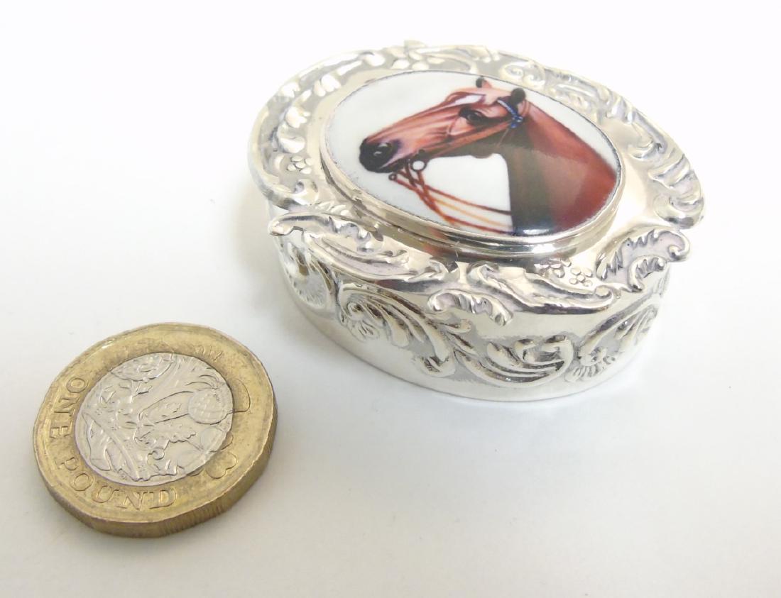 A pill box of ovoid form having enamel cabochon to lid,: A pill box of ovoid form having enamel cabochon to lid, depicting a horses head, 1 3/4'' x 1 1/2'' x 3/4''