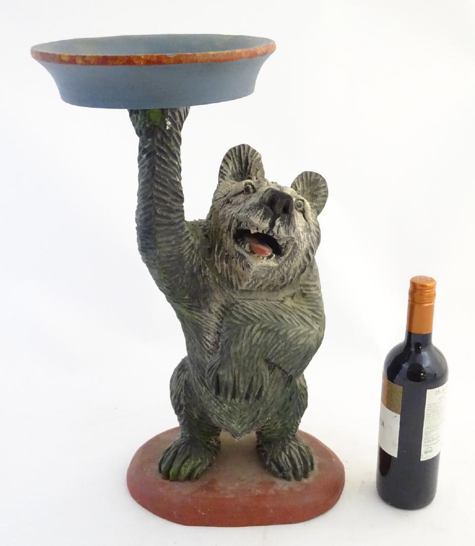 Carved wood Swiss bear: a painted carved wooden drinks: Carved wood Swiss bear: a painted carved wooden drinks table formed as a bear holding a tray on shaped base , 21'' high.