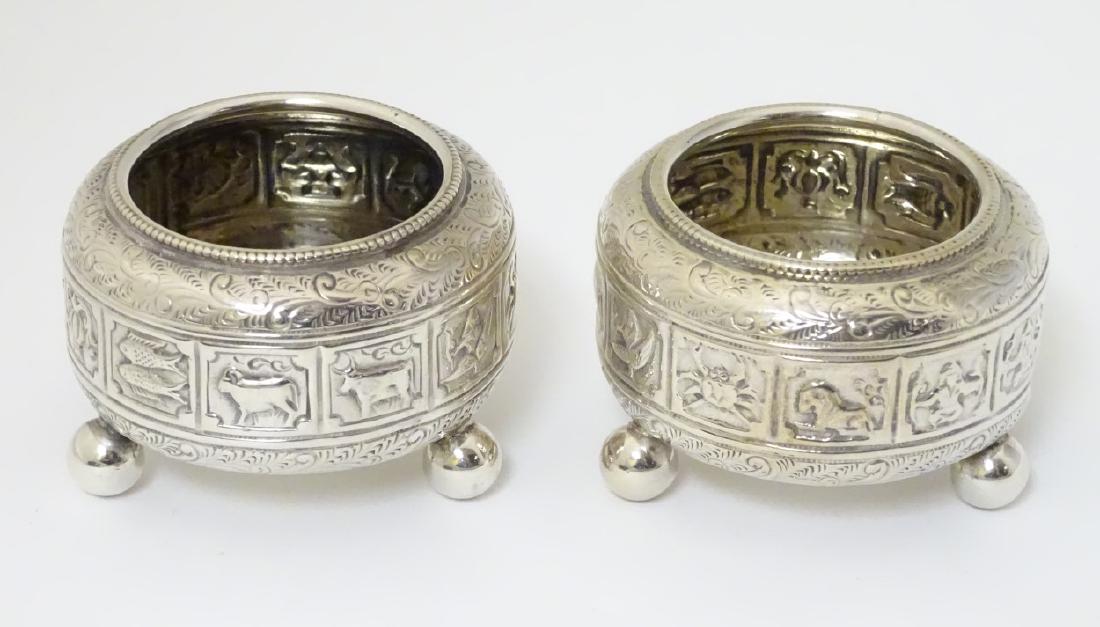 A pair of Victorian silver salts hallmarked Birmingham: A pair of Victorian silver salts hallmarked Birmingham 1881 maker Elkington & Co ( Frederick Elkington) and having banded decoration depicting signs of the zodiac etc. 2 1/4'' diameter (112g)