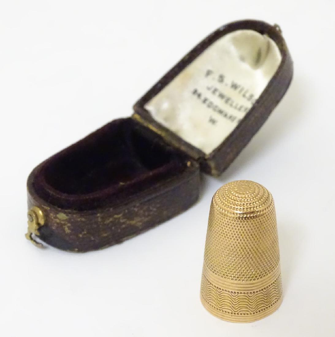 A gold thimble. ( Unmarked - tests at 15ct) cased.: A gold thimble. ( Unmarked - tests at 15ct) cased.