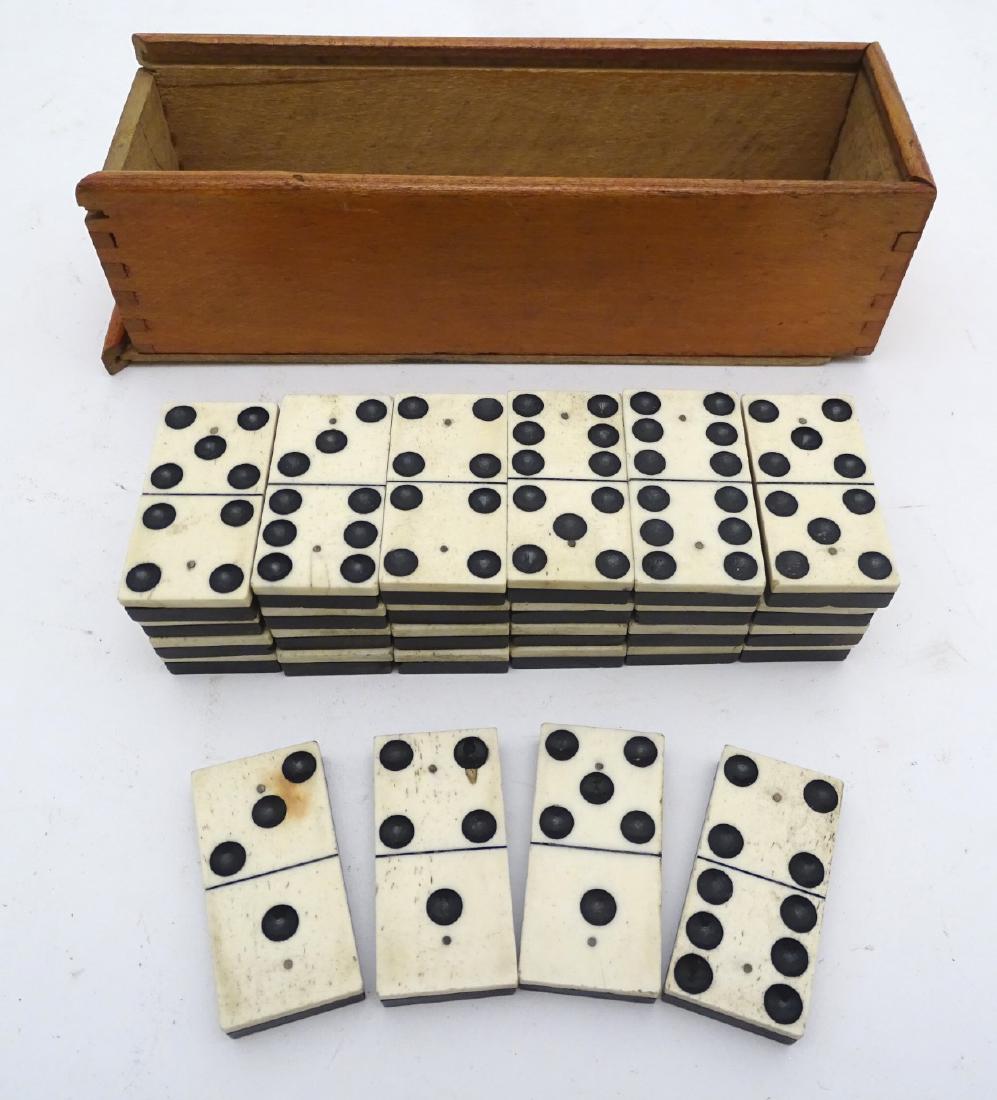 A set of half bone, half ebony dominoes, in a sliding: A set of half bone, half ebony dominoes, in a sliding wooden box, each piece 2 1/8'' x 1'' (28 pieces +1)