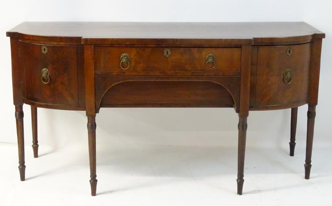 A late 19thC / early 20thC mahogany sideboard with a: A late 19thC / early 20thC mahogany sideboard with a break front top, single long drawer above a cutlery drawer, flanked by a cellarette drawer and cupboard containing short drawer within, standing on
