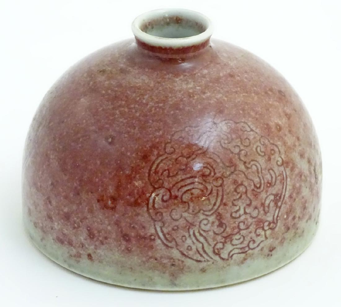 A Chinese sang-de-boeuf pot/taibai zun formed as a: A Chinese sang-de-boeuf pot/taibai zun formed as a dome, decorated with three stylised dragon roundels. Character marks to base. Approx. 3 1/2'' high.
