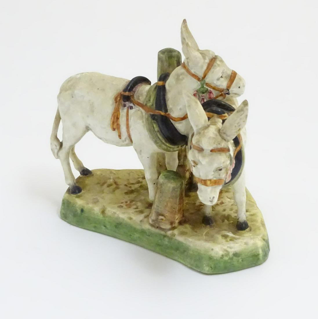 A Royal Dux style figure group of two standing donkeys: A Royal Dux style figure group of two standing donkeys on a base. Incised under '1116'. Approx. 6 ½'' high.