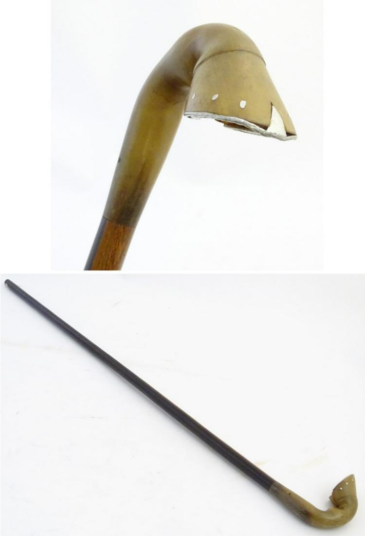 Walking Stick : a horseshoe walking stick, the handle: Walking Stick : a horseshoe walking stick, the handle formed as a horse's hoof (from cow horn). The detailed horseshoe made of white metal attached with small white metal nails. Mounted onto an ebony