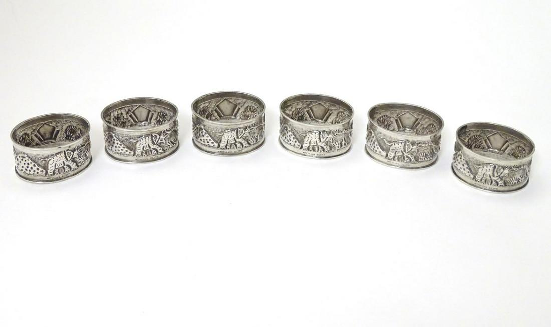 A set of 6 Anglo Indian silver napkin rings decorated: A set of 6 Anglo Indian silver napkin rings decorated with elephants in landscape and marked ' Sterling Silver'