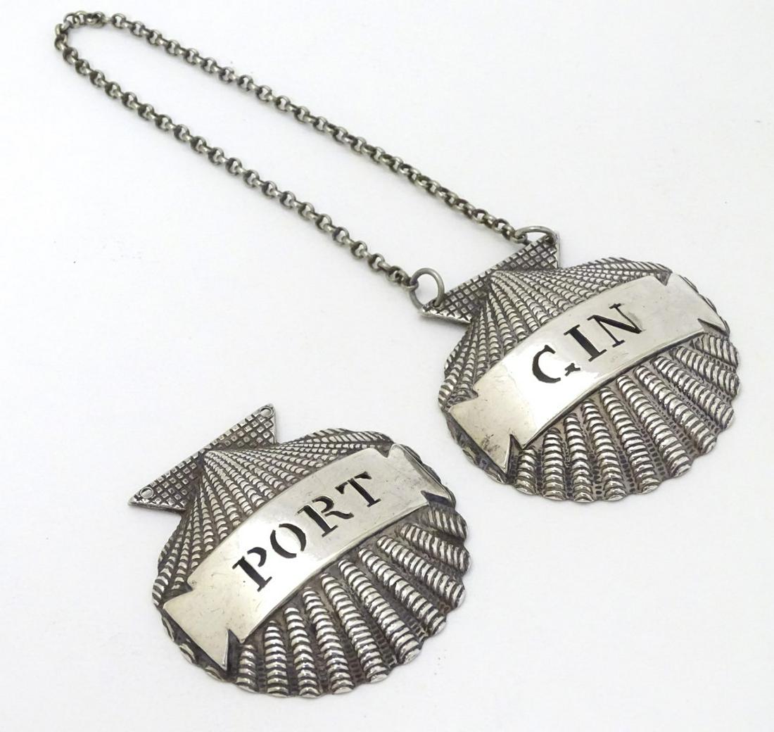 Two silver plate decanter labels / bottle tags of: Two silver plate decanter labels / bottle tags of scallop shell form 'Gin' and 'Port. ' 2'' wide