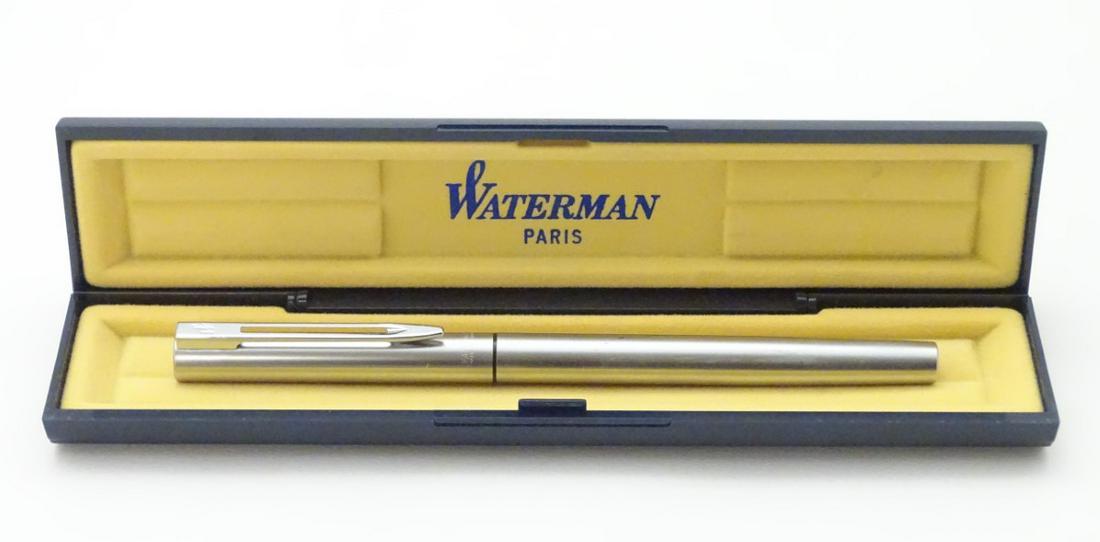 A cased fountain pen by Waterman, Paris, with steel: A cased fountain pen by Waterman, Paris, with steel finish. 5 3/8'' long.