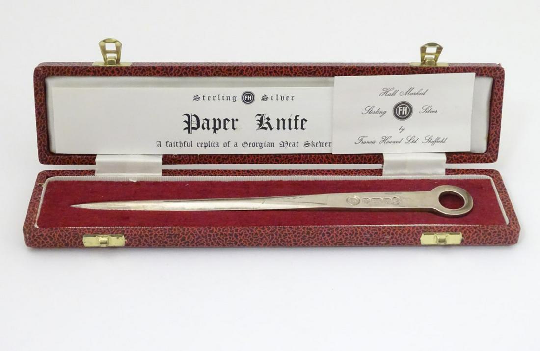 A cased silver paper knife formed as a ' Faithful: A cased silver paper knife formed as a ' Faithful Replica of a Georgian Meat Skewer' hallmarked Sheffield 1977 with silver jubilee mark. Maker Francis Howard Ltd. Approx 8 1/4'' long